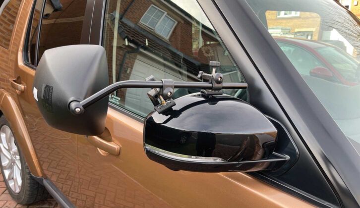 A towing mirror in place on a car
