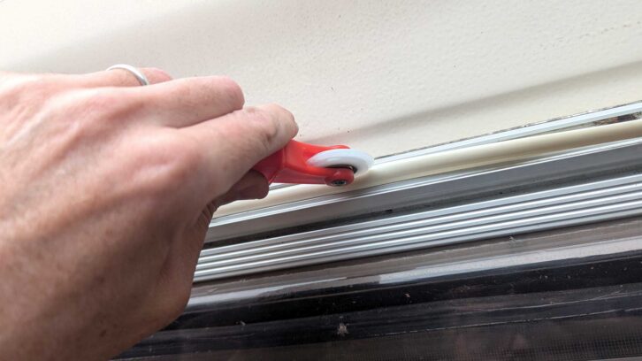 Pushing the trim into the channel with the roller end