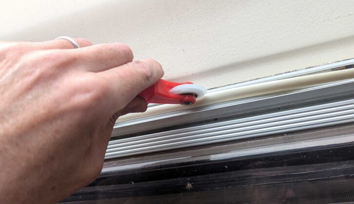 Pushing the trim into the channel with the roller end