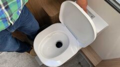 A person flushing a caravan toilet