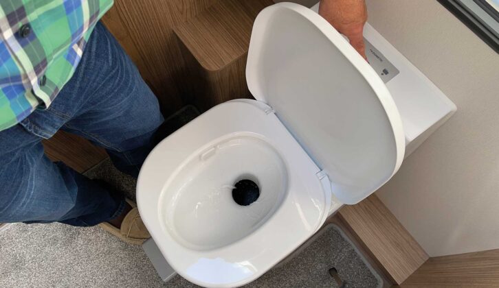 A person flushing a caravan toilet