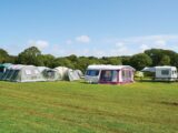 A caravan on a campsite with an awning set up