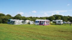 A caravan on a campsite with an awning set up