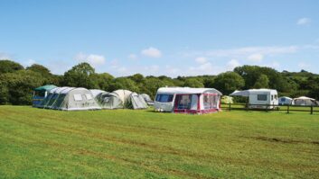 A caravan on a campsite with an awning set up