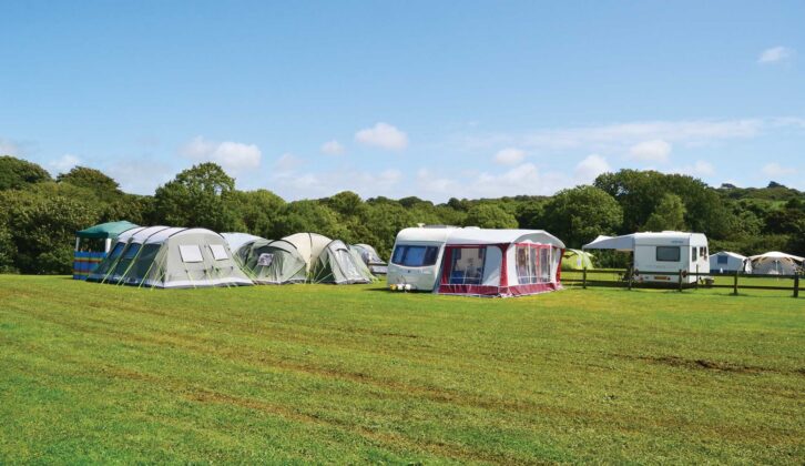 A caravan on a campsite with an awning set up