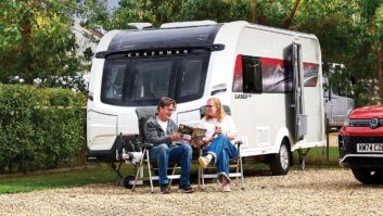 Peter sitting outside a Coachman Laser 480 Xtra with somebody else